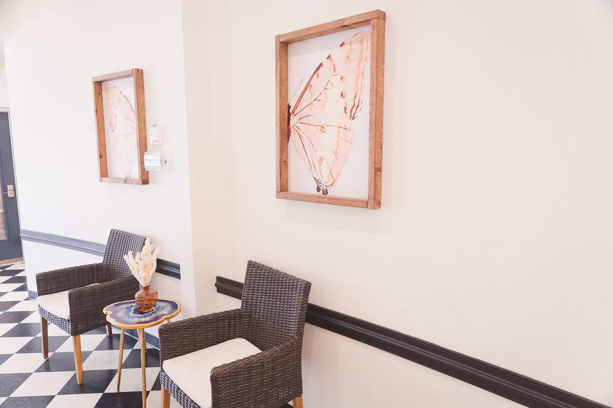 Seating area at WanderLux Southpoint with woven chairs and a checkered tile floor