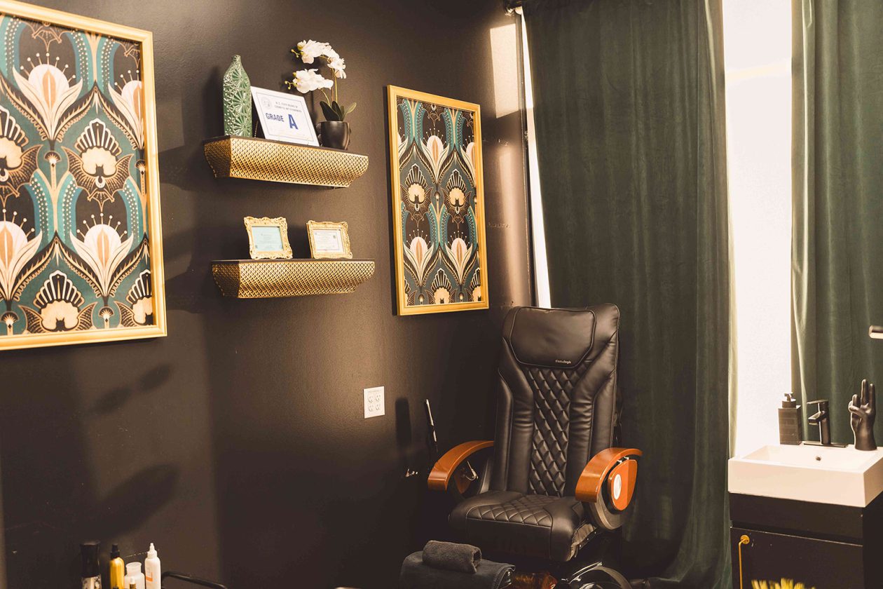 Art deco styled suite at WanderLux University Hill with a pedicure chair and emerald curtains